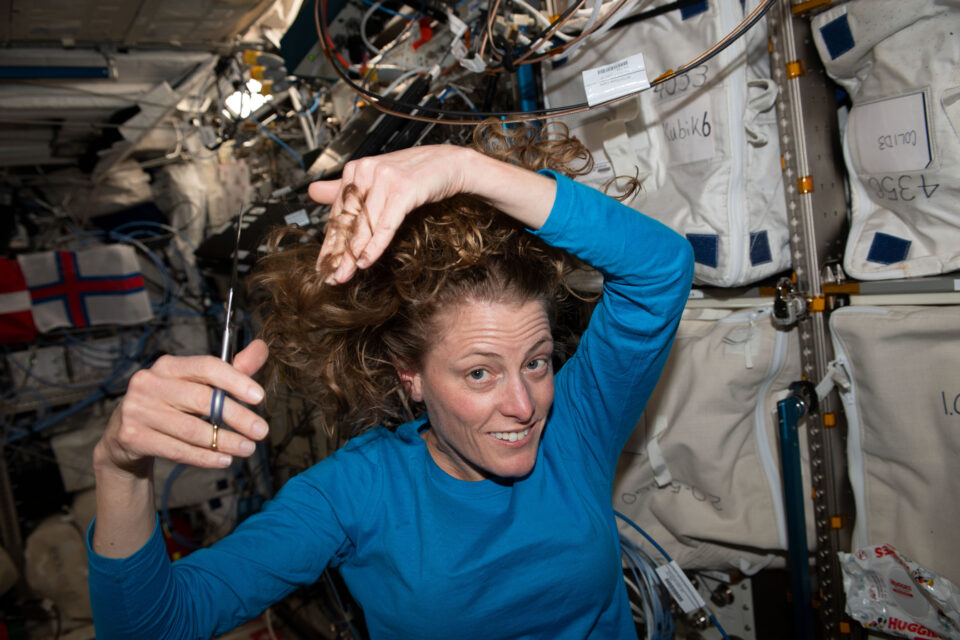 Astronaut Loral O’Hara is pictured trimming her hair